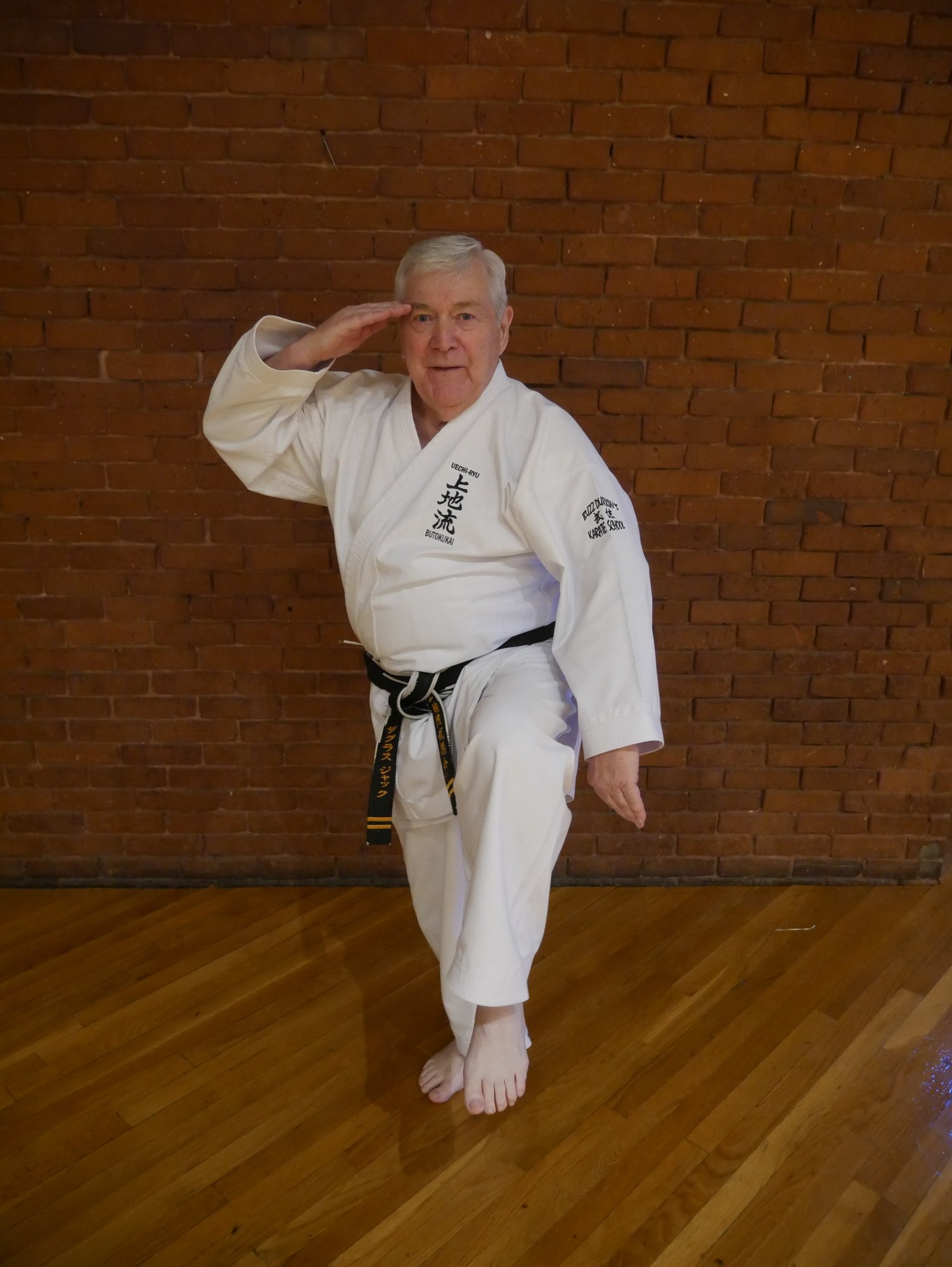 Douglass Jack performing a karate stance in a white uniform