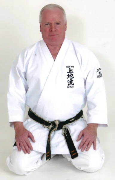 Sensei Buzz Durkin kneeling in his karate uniform